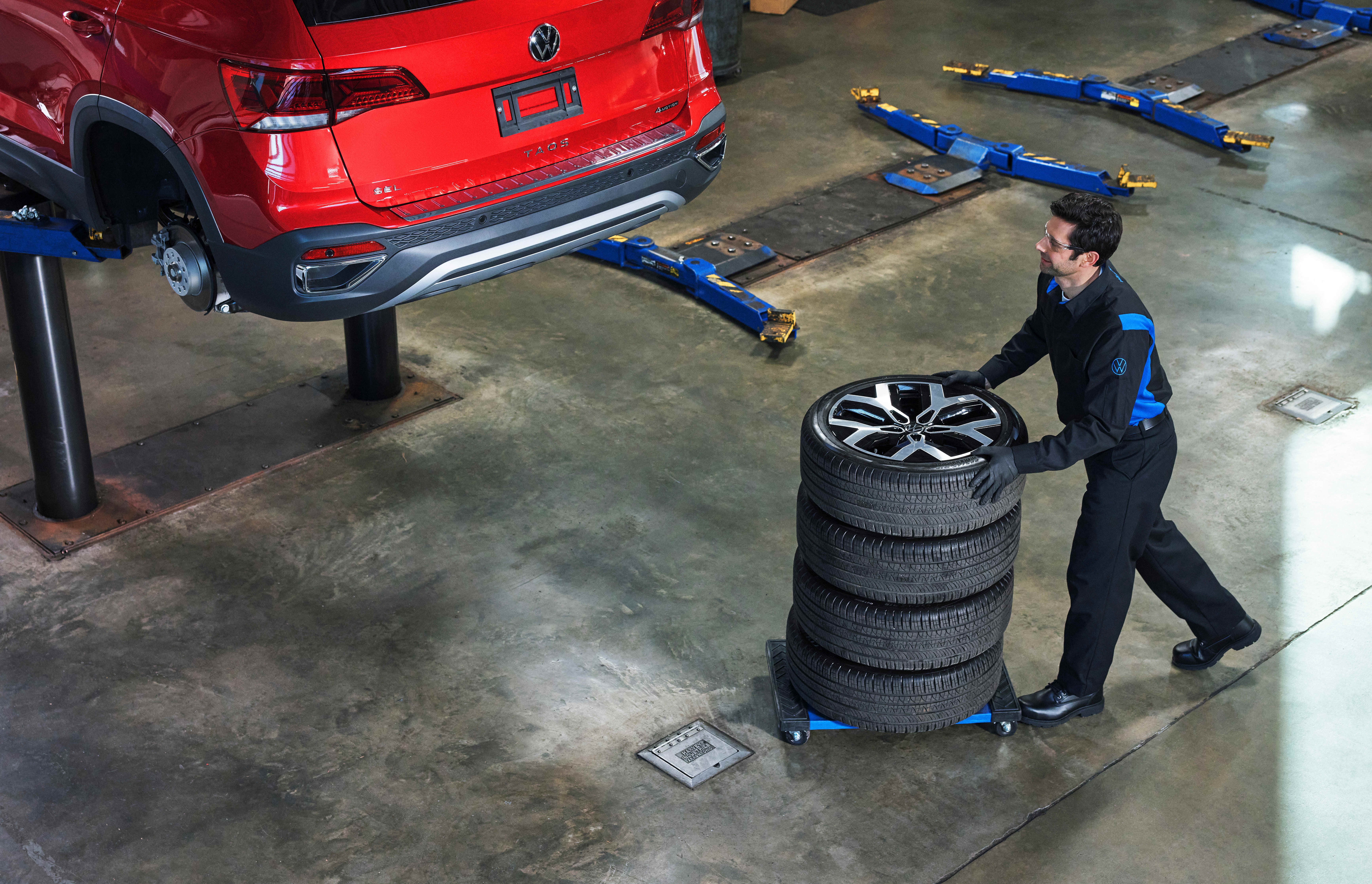 Volkswagen technician balancing winter tires on dynamic balancing equipment