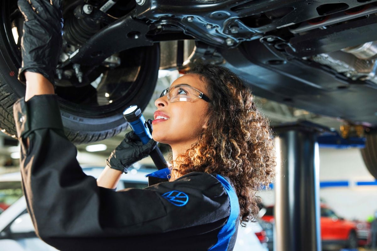 Certified Volkswagen Mechanic performing 4MOTION undercarriage inspection